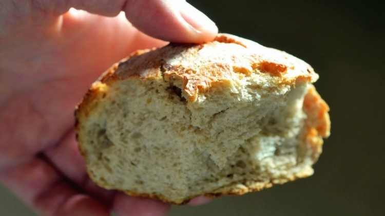 wyciągnięta dłoń z przełamanym chlebem